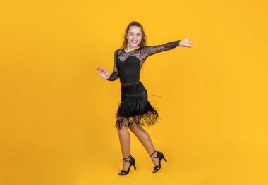 Tatlı kız balo dansçısı siyah elbiseler giyip dans ediyor.