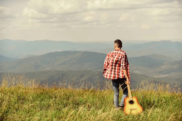 Świetna muzyka. szczęśliwy i wolny. Kowboj z umięśnionym tułowiem. gitarzysta akustyczny. piosenka country. Seksowny facet z gitarą w szachownicy. moda hipsterska. zachodni kemping i turystyka — Zdjęcie stockowe