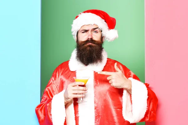 Ernster bärtiger Weihnachtsmann darauf auf buntem Studiohintergrund — Stockfoto