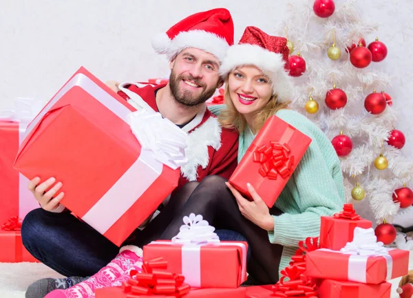 爱情是最好的礼物。一起开始新的一年。恋爱中的夫妻享受圣诞节庆祝活动。可爱的女人和留胡子的男人都戴着圣诞老人背景的圣塔克洛斯帽。平安夜与亲爱的 — 图库照片