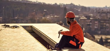 Isı yalıtımı. Profesyonel tamir çatısı. Düz çatı kurulumu. Roofer yeni çatı yapıyor. Çatıda adam var. Projeler için tahmini malzeme gereksinimleri. Çatı malzemeleri yükle
