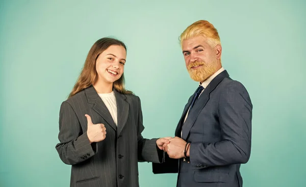 Business success. family business. partnership. teamwork of daughter and dad. business meeting. modern office life. businessman dyed blond hair. small girl in oversized suit jacket. future career
