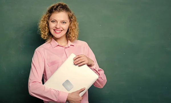 学校讲师讲解主题.回学校去教信息学学校教育概念。女人可爱的老师抱着笔记本电脑站在黑板旁边.教师软件。现代教育 — 图库照片