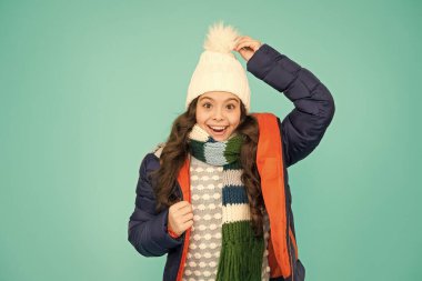 Ne şapka ama. Mutlu çocuk kalın bir şapka takıyor. Küçük kız ponpon şapkalı gülümsüyor. Kış için moda aksesuar. Moda ve tarz. Soğuk hava için sıcak ve şık bir şapka.