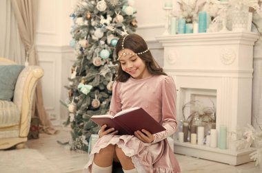 Noel 'in günlerini okuyorum. Şirin küçük kız Noel ağacında kitap okuyor. Sevimli küçük çocuk Xmas hikayelerini okumaktan zevk alıyor. Noel okuması. Okumada sihirli xmas