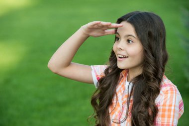 Uzun dalgalı saçlı, ilham verici kız. Uzağa bak. Alnında yeşil çimenler tut.