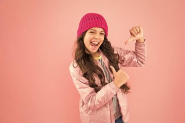 En sevdiğim giysi malzemesi. Soğuk kışa hazır olun. Soğuk iklim havası. Mutlu küçük kız pembe arka plan. çocuk ceketi ve örgü şapka. Kış alışverişi. Kışın nasıl sıcak giyileceğini