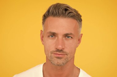 Cilt bakımı çok önemli. Yakışıklı adam sarı arka plan. Normal cilt ve sakallı, beyaz bir adam. Deri sağlığı. Cilt ürünleri. Cilt rutini ve bakım. Orta yaşlı erkekler için cilt bakımı