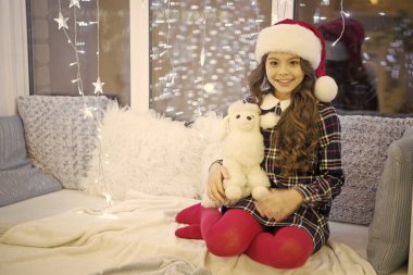 Kış bayramı. İyi tatiller. Evdeki çelenk ışıklarındaki küçük kız. Yeni yıl. Noel Baba. Küçük kız hediye aldı. Şimdiki Xmas. Kış anıları. Evdeki çocuk rahat pencere pervazında dinleniyor.