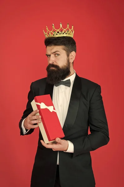 Ser completamente egoísta. Egoist mantenga la caja actual fondo rojo. El hombre barbudo lleva corona. Egoísta o gran jefe. Egoísta y egoísta. Egoísmo y vanidad. Orgullo y altivez. Celebración festiva — Foto de Stock