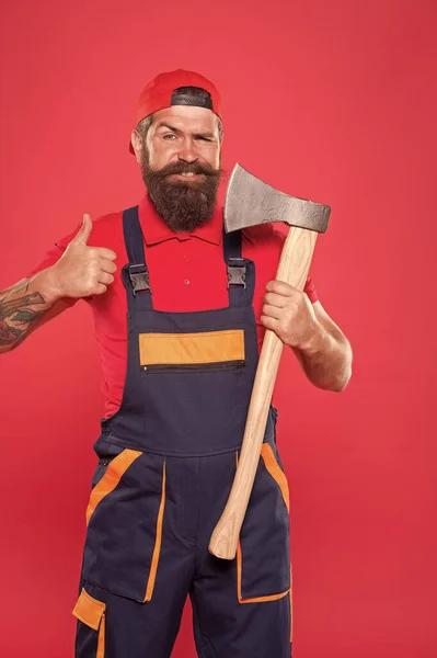 Conceito de perigo. Homem barbudo segurar machado fundo vermelho. Conceito de renovação. Um faz-tudo barbudo. Trabalhador corajoso. A cortar barba. Brutalidade e masculinidade. Lenhador barbudo. Homem construtor uniforme segurar machado — Fotografia de Stock