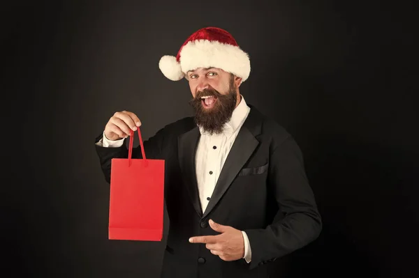 Prodotto si dovrebbe comprare durante le vacanze di Natale. Uomo barbuto che presenta il prodotto. Il capo felice punta il dito contro la borsa della spesa. Promozione prodotti. Vendita di Natale. Pubblicità del prodotto, spazio di copia — Foto Stock