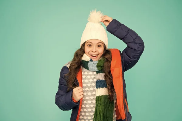 Wat een hoed. Gelukkig kind draagt warme hoed. Klein meisje glimlach in pompom hoed. Fashion accessoire voor de winter. Mode en stijl. Warme en stijlvolle muts voor koud weer — Stockfoto