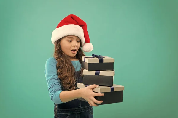 A criança recebeu um presente surpresa. Feliz Ano Novo. Embalagem para presentes. Muitos presentes. Natal celebrado em todo o mundo. Menina pequena segurar pilhas caixas de presente. Conceito generoso de presente. Compras online. Venda de inverno — Fotografia de Stock