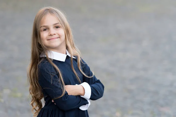 Iniciante confiante. Criança feliz usar uniforme ao ar livre. Volta para a escola. Moda escolar. Belo olhar. Educação infantil. Desfrutando da vida dos alunos, espaço de cópia — Fotografia de Stock