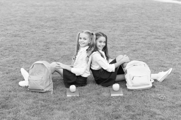 W przyjaźni jest szczęście. Szczęśliwe dzieci cieszą się przyjaźnią. Przyjaciele ze szkoły siedzą na zielonej trawie. Małe dzieci wracają do szkoły. Międzynarodowy dzień przyjaźni. Lojalność i zaufanie to przyjaźń — Zdjęcie stockowe