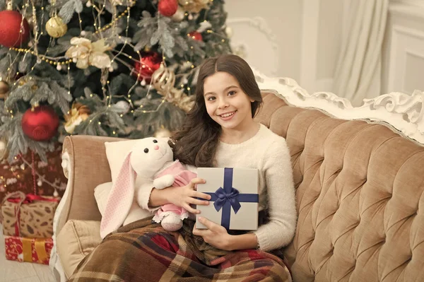 Felicidades. a criança alegre encontra presentes na árvore de Natal. sentir-se confortável em casa. feliz ano novo humor. alegria e alegria. Presentes de Natal na loja de crianças. menina pequena amo seu coelho. melhor presente de brinquedo de Natal — Fotografia de Stock