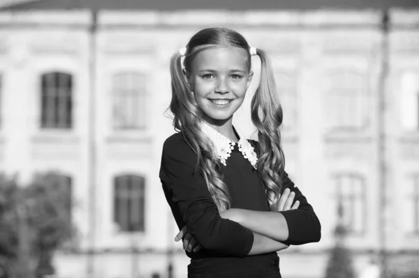 Bezoek uw salon regelmatig. Gelukkig kind draagt schooluniform buiten. Klein meisje met lang blond haar. Kapsalon. Salon haarverzorging. Schoonheidssalon. Schoonheidsmiddelen. Kinderen kapper. Terug naar school special — Stockfoto