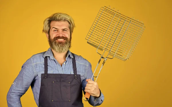 Gelukkig hipster houden kookgerei voor barbecue. Een man met een baard. Gereedschap voor het roosteren van vlees buiten. Picknick en barbecue. Klaar voor barbecue feestje. Culinair concept. zomers weekend — Stockfoto