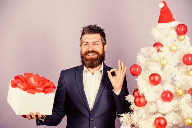 Ofis noel partisi. Adam sakallı hippi resmi takımı Noel ağacının yanında. Noel hediyeleri ve dekorasyonlar. Gizli Noel Baba konsepti. Kış tatili Noel selamları. Meslektaşlar için en iyi hediyeler