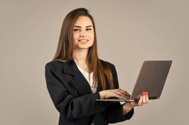 Başarılı kadın bilgisayarda çalışıyor. Kendine güvenen bir ofis çalışanı Moda güzelliği. Resmi moda tarzı. Moda makyajlı esmer kadın. Ceketli seksi kız dizüstü bilgisayar tutuyor.