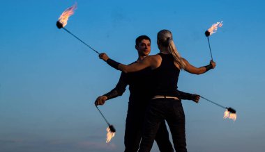 Dinamik ateş gösterisi. Seksi çift poi dansı yapıyor mavi gökyüzü. Poi performansı. Ateş dansı. Gece partisi. Tatil kutlaması. Sanat icra etmek. Eğlence ve eğlence