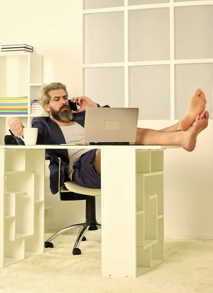 Small business. networking while staying at home. Technology. Handsome man use laptop at home. self quarantine routine. Serene barefoot guy resting, daydreaming at home. remote workday with computer