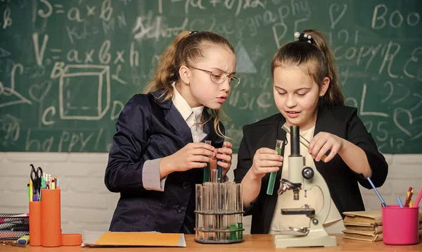 Laboratório de Biologia. Feliz génio. Pequenas cientistas com microscópio. Raparigas génio no laboratório da escola. Laboratório de ciências. experimento científico em laboratório. Pesquisa de química em laboratório. Química é divertido — Fotografia de Stock