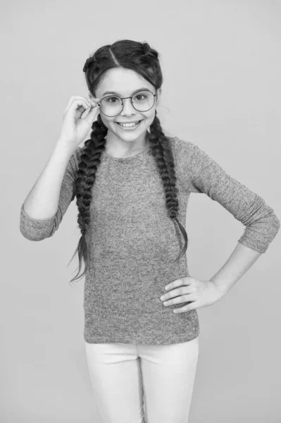 'σε με να δω. Διαβάζει καλύτερα με γυαλιά. Γυαλιά για την υγεία των ματιών. Έξυπνο κορίτσι. Η μαθήτρια φοράει γυαλιά ηλίου κίτρινο φόντο. Αξιολάτρευτο φυτό. Σχολική ιδέα. Έξυπνο κορίτσι κακή όραση — Φωτογραφία Αρχείου