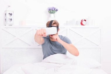 Bu yeni teknolojiden faydalanıyor. Beyaz adam evde eğlenmek için sanal gerçeklik teknolojisi kullanıyor. Yenilikçi teknoloji deneyimi olan yakışıklı bir adam. Teknoloji burada.