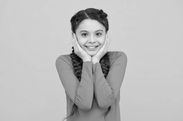 Niño sonriente con el pelo largo. adolescente alegre con sonrisa saludable. Cabello trenzado en trenzas. poca belleza gratamente sorprendida. Feliz infancia. La pequeña tiene una sonrisa bonita. peinado infantil moda —  Fotos de Stock