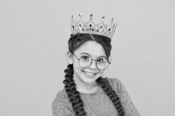 小さなスマートガールは眼鏡をかける。賢い子だ。王立教育。かわいいメガネのかわいい女の子。プリンセスのコンセプト。幸せな笑顔の王女。優秀な生徒だ。成功と幸福。一番賢い姫 — ストック写真