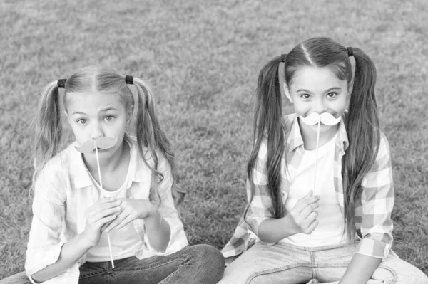 Os verdadeiros amigos nunca se separam. Amigos felizes seguram adereços de bigode. Amigos da infância. Pequenos amigos festa na grama verde. Um ar louco de meninas. Família. Relacionamento. Questões de amizade — Fotografia de Stock