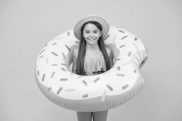 Natação e banho de sol. Férias. Descanse à beira-mar. Festa na piscina. Feliz infância. Conceito de entretenimento. Menina e anel de donut natação. Miúdo de fato de banho a divertir-se com actividades aquáticas — Fotografia de Stock