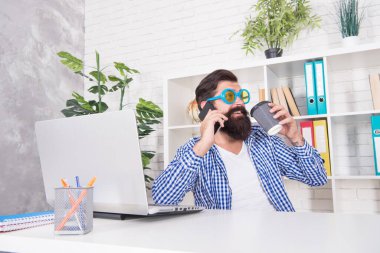 Yudumlamak olur. İş adamı kahve içer ve cep telefonuyla konuşur. İş görüşmesi. Kahve molasının tadını çıkarıyorum. Sıcak fincan. Kahvaltılık çay. Sabah alışkanlığı. Ofis hayatı. Basit bir zevk.