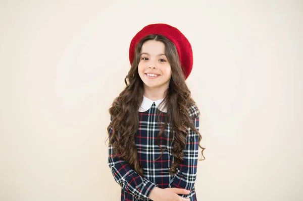 Criança menina pequena com cabelo encaracolado longo. uniforme escolar elegante. moda infantil. menina da moda parisiense. Dia das crianças. criança no fundo amarelo. menina feliz em boina francesa. Humor alegre — Fotografia de Stock