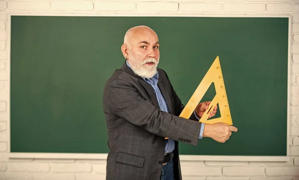 Domina los conceptos clave. de vuelta a la escuela. concepto de matemáticas y personas. Matemáticas a bordo. tema favorito. Profesor senior usa una herramienta de triángulo matemático. tutor barbudo en pizarra —  Fotos de Stock