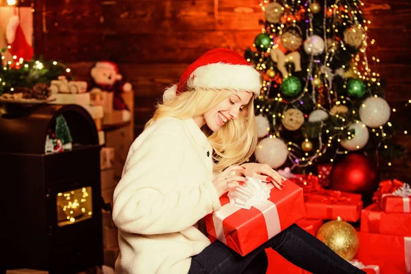 圣诞老人送的快乐的女孩红桑塔帽。圣诞节礼物。装饰一下圣诞树吧。快乐的女人爱礼物。冬季购物销售。在家里庆祝新年。最后的准备圣诞节期间 — 图库照片