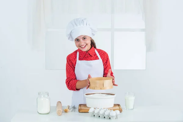 Delicaat. Traditionele keuken. Het kind heeft plezier met eten in de keuken. Kind en bakken. Gezond eten en levensstijl concept. meisje dat deeg maakt van bloem en eieren. Dieet en gezondheid. culinaire school — Stockfoto