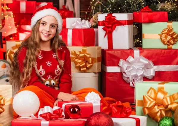 Papá Noel me trajo regalos. Tienda de regalos. Mágico y acogedor. Felicidad y alegría. Niño feliz chica encontrar regalos cerca del árbol de Navidad. Feliz navidad. Concepto de infancia feliz. Kid santa hat cajas de regalo de Navidad —  Fotos de Stock