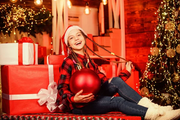 Noche de Navidad. entrega regalos de Navidad. Feliz año nuevo. niño en sombrero de santa rojo. Niño retrato con regalo. venta de compras de invierno. niña sonriente. Hermosa habitación decorada Holdiay con árbol de Navidad —  Fotos de Stock