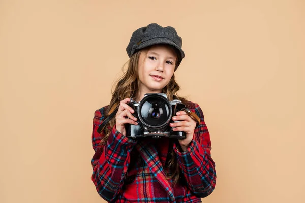 Веселый ребенок в головном уборе и клетчатой куртке использовать винтажную камеру, ретро-фотографирования — стоковое фото