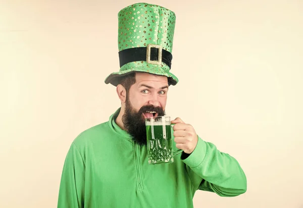 Irish culture. Man bearded hipster funny hat drink pint beer. Cheers concept. Colored green beer. Green beer part of celebration. Irish pub. Alcohol consumption integral part saint patricks day — Stock Photo, Image