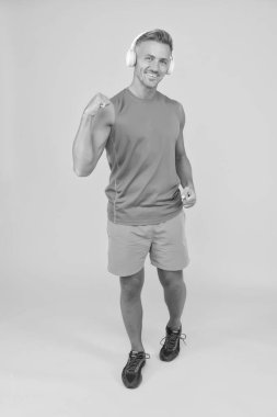 Düzenli antrenman. Olgun koç. Güçlü sporcu kulaklık takar ve forma giyer. Sağlıklı sporcu ya da sporcu. Spor ve spor. Fitness müziği. Sporcu, müzik dinle. Sporcu eğitimi