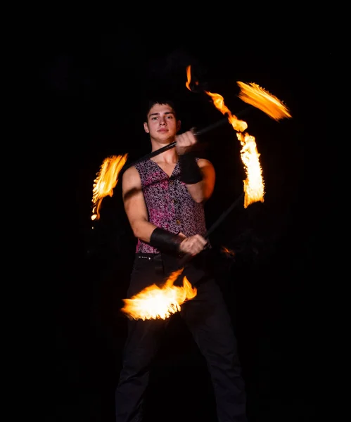 燃烧的能量。英俊的男人在舞动着燃烧的警棍.火杂耍。火能。精力充沛的旋转。火焰和火花。夜表演。娱乐表演。点亮它，扭动它 — 图库照片