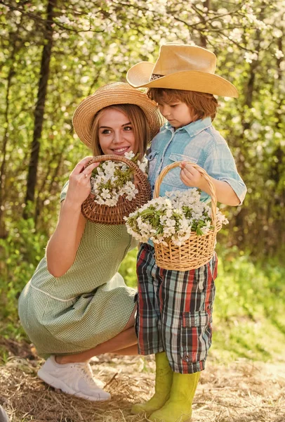 Happy mothers day. Family farm. Spend time together. Lovely family outdoors nature background. Farmers in blooming garden. My sweet baby. Ranch concept. Growing flowers. Mother and cute son in hats