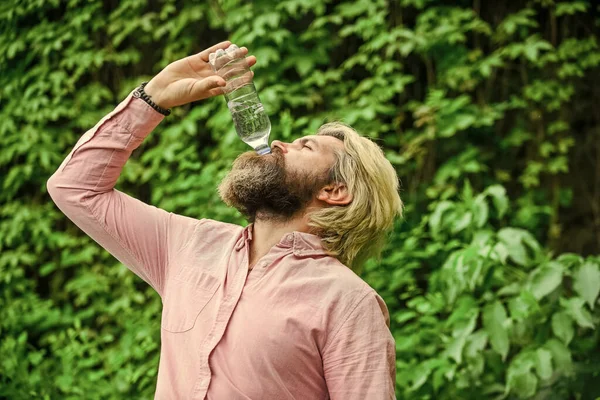 För dräggen. törst. Drick lite vatten medan du går i parken. Bli pigg. Behåll vattenbalansen i kroppen. brutalt manliga hipster dricka vatten. skäggig man hålla plastflaska vatten — Stockfoto