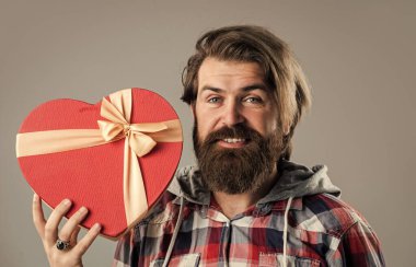 Ben de seni seviyorum. Boks günü konsepti. Sevgililer günü hediyesi. Sevgilim olur musun? Acımasız yetişkin hipster kalp kutusunu tutuyor. Onun için mükemmel bir hediye. Sakallı adam sevgisini ifade eder. Bayram aşkı. Erkek alışverişe gider