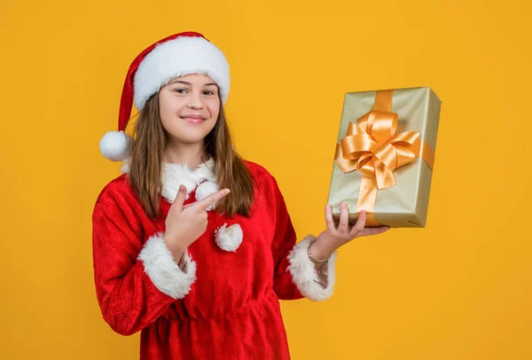 快乐的圣诞女孩戴着红色的圣诞老人帽和服装，拿着礼物盒，拳击日 — 图库照片