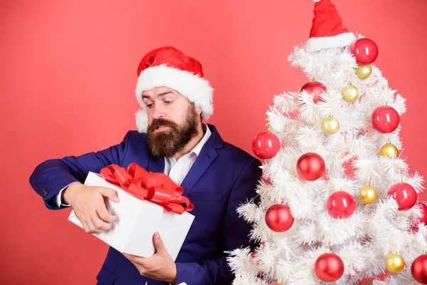 Sorpresa di Capodanno. uomo festeggiare festa all'albero di Natale. Idea regalo. Invia o ricevi regalo di Natale. Buone feste. saldi invernali. shopping natalizio. barbuto uomo Babbo Natale cappello — Foto Stock